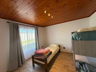 a small bedroom with a bed and a window at Los Pinos in Achiras