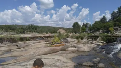 a person standing on some rocks near a river at Casa Minimalista con Pileta Privada en el mejor lugar de Cabalango in Cavalango