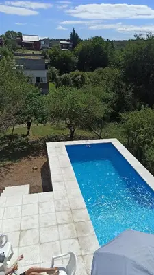 a blue swimming pool in a yard with trees at Casa Minimalista con Pileta Privada en el mejor lugar de Cabalango in Cavalango