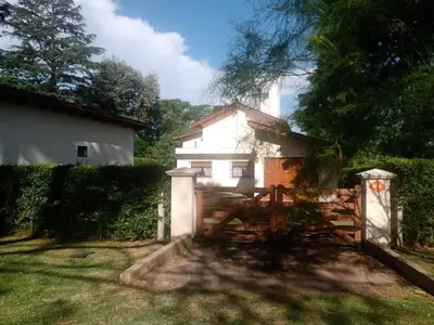 a gate in front of a white house at Casa La Escondida in Villa del Dique