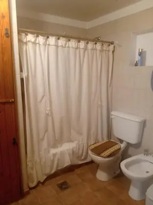 a bathroom with a toilet and a shower curtain at Casa La Escondida in Villa del Dique