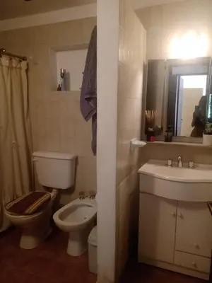 a bathroom with a toilet and a sink and a mirror at Casa La Escondida in Villa del Dique