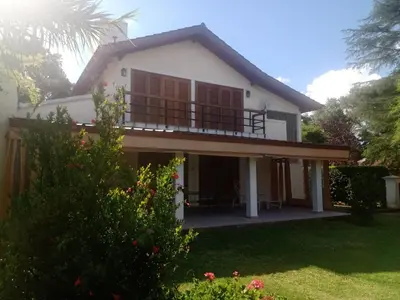 a house with a balcony and a yard at Casa La Escondida in Villa del Dique