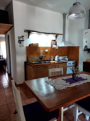 a kitchen with a wooden table and a kitchen with a stove at Casa en Nono in Nono