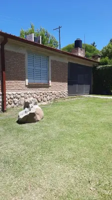 a house with a rock in front of a yard at Casa en Nono in Nono