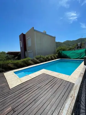 a swimming pool on top of a wooden deck at Cabañas El Pela in Villa Carlos Paz