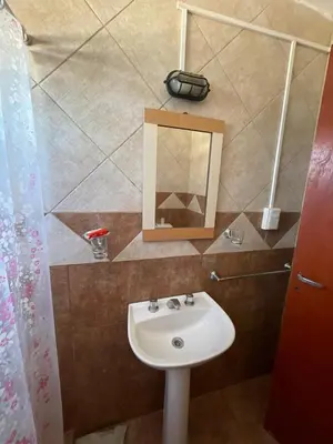 a bathroom with a sink and a mirror at Cabañas El Pela in Villa Carlos Paz