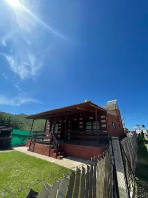 a building with a fence in front of it at Cabañas El Pela in Villa Carlos Paz