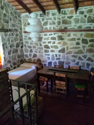 a room with a table and a stone wall at Valle Iguana in San Lorenzo