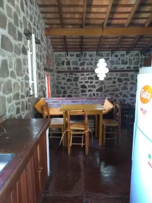 a table and chairs in a kitchen with a stone wall at Valle Iguana in San Lorenzo