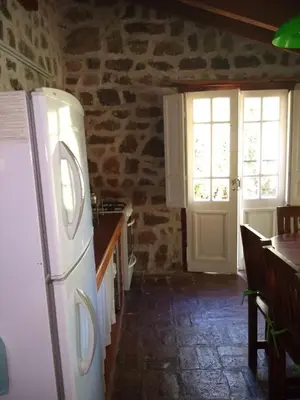 a kitchen with a white refrigerator in a stone wall at Valle Iguana in San Lorenzo