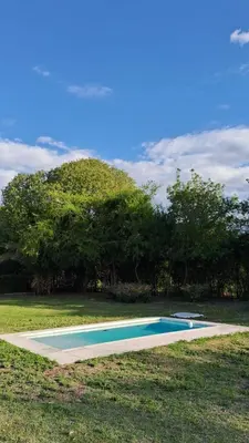 a swimming pool in the middle of a field at Lo de Abu in Villa de Las Rosas