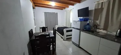 a kitchen with a counter and a table and a kitchen with a tableablish at Apartamento Jhaky in Villa Carlos Paz
