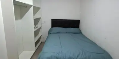 a small bedroom with a bed with a black headboard at Apartamento Jhaky in Villa Carlos Paz