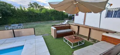 a patio with an umbrella and a bench and a table at Casa Jhaky in Villa Carlos Paz
