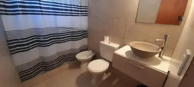 a bathroom with a toilet and a sink and a shower curtain at Casa Jhaky in Villa Carlos Paz