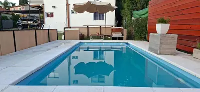 a swimming pool with a bat stencil on the side of a house at Casa Jhaky in Villa Carlos Paz