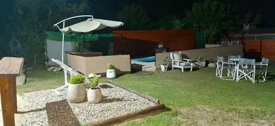 a backyard with an umbrella and some plants and chairs at Casa Jhaky in Villa Carlos Paz