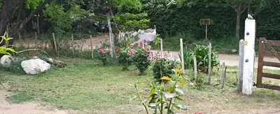 a garden with flowers and a wooden fence at El mamboreta in Pantanillo