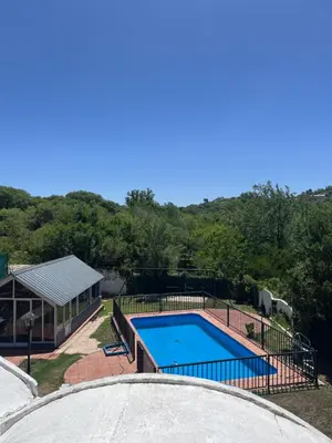 a swimming pool in a yard next to a house at Departamento en Villa Carlos paz in Villa Carlos Paz