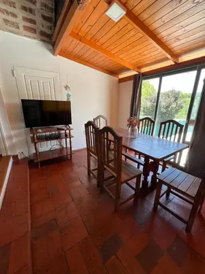 a dining room with a table and chairs and a television at Departamento en Villa Carlos paz in Villa Carlos Paz