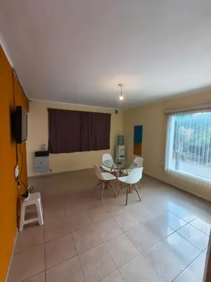 a living room with a table and chairs and a window at Quique1 in Pilar