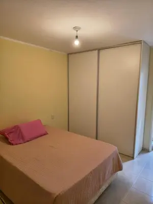 a bedroom with a bed with a red pillow on it at Quique1 in Pilar