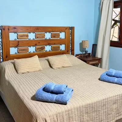 a bedroom with a bed with two towels on it at Casa completa con piscina a 600 metros de plaza de Villa de las Rosas in Villa de Las Rosas