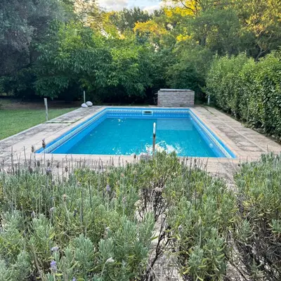 a swimming pool in the middle of a garden at Casa completa con piscina a 600 metros de plaza de Villa de las Rosas in Villa de Las Rosas