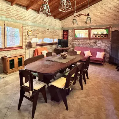 a dining room with a wooden table and chairs at Casa completa con piscina a 600 metros de plaza de Villa de las Rosas in Villa de Las Rosas