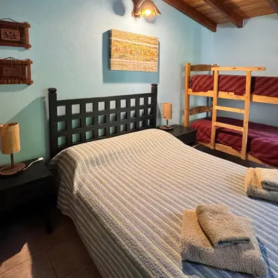 a bedroom with two beds and a bunk bed at Casa completa con piscina a 600 metros de plaza de Villa de las Rosas in Villa de Las Rosas