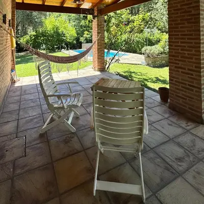 two chairs and a hammock on a patio at Casa completa con piscina a 600 metros de plaza de Villa de las Rosas in Villa de Las Rosas