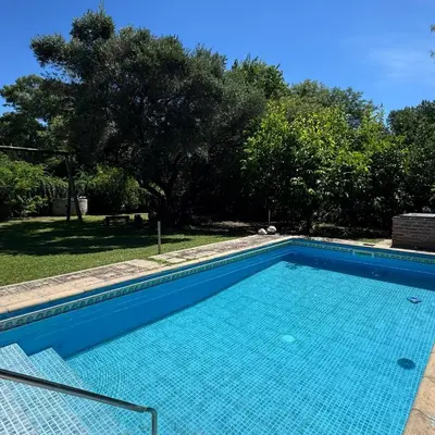 a large blue swimming pool in a yard at Casa completa con piscina a 600 metros de plaza de Villa de las Rosas in Villa de Las Rosas