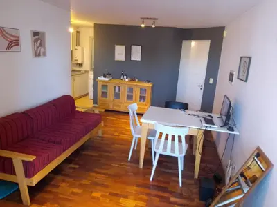 a living room with a red couch and a table and chairs at S rosa centro in Cordoba