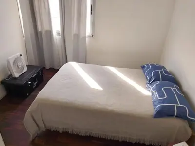 a bedroom with a bed with blue pillows and a window at S rosa centro in Cordoba