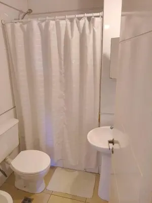 a bathroom with a white shower curtain and a toilet at S rosa centro in Cordoba