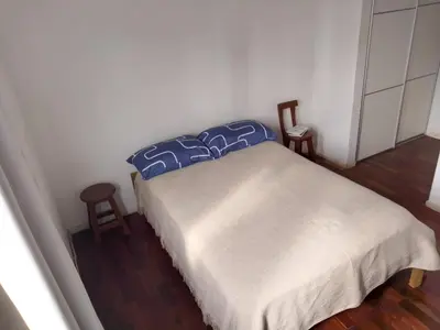 a small bedroom with a bed and two chairs at S rosa centro in Cordoba