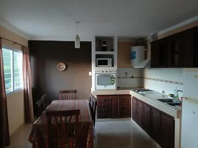a small kitchen with a table and a microwave at Aguaribay in Villa Los Aromos
