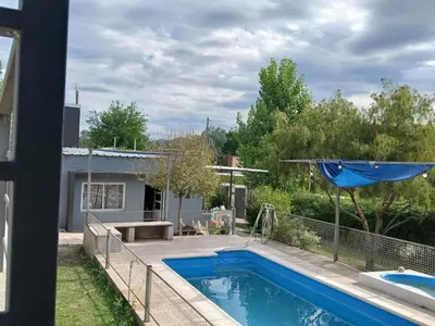 a backyard with a swimming pool and an umbrella at Aguaribay in Villa Los Aromos