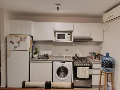 a kitchen with a washing machine and a refrigerator at Dpto 1 dormitorio luminoso zona Nuevocentro in Cordoba