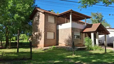 a brick house with a roof at El Balcón de la Costanera in Santa Rosa de Calamuchita