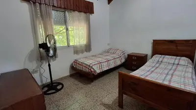 a bedroom with two beds and a window at El Balcón de la Costanera in Santa Rosa de Calamuchita