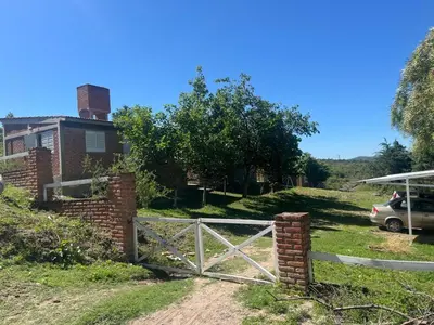 a white fence in front of a house at Cabañas el atardecer de Andrés - Flor Serrana - Tanti in Tanti