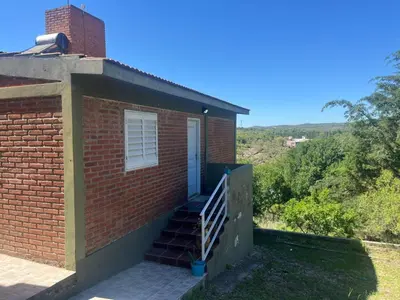 a brick house with stairs leading to a door at Cabañas el atardecer de Andrés - Flor Serrana - Tanti in Tanti