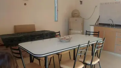 a kitchen with a white table with chairs and a counter at Cabañas el atardecer de Andrés - Flor Serrana - Tanti in Tanti