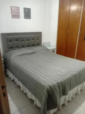 a bedroom with a bed with a gray comforter at Nueva Córdoba primer piso Externo in Cordoba