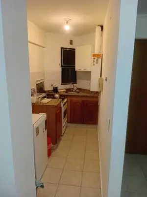 a kitchen with brown cabinets and a white refrigerator at Nueva Córdoba primer piso Externo in Cordoba