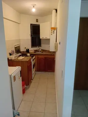 a kitchen with wooden cabinets and a white refrigerator at Nueva Córdoba primer piso Externo in Cordoba