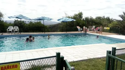 a group of people in a swimming pool with umbrellas at Alto de Balcón in Tanti