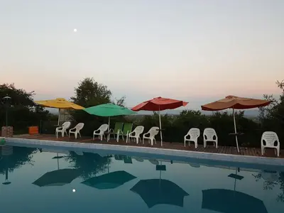 a group of umbrellas and chairs next to a swimming pool at Alto de Balcón in Tanti